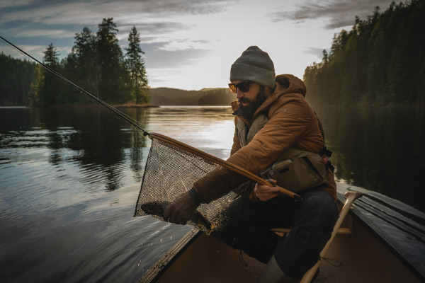 man pulling fish from fishing net
