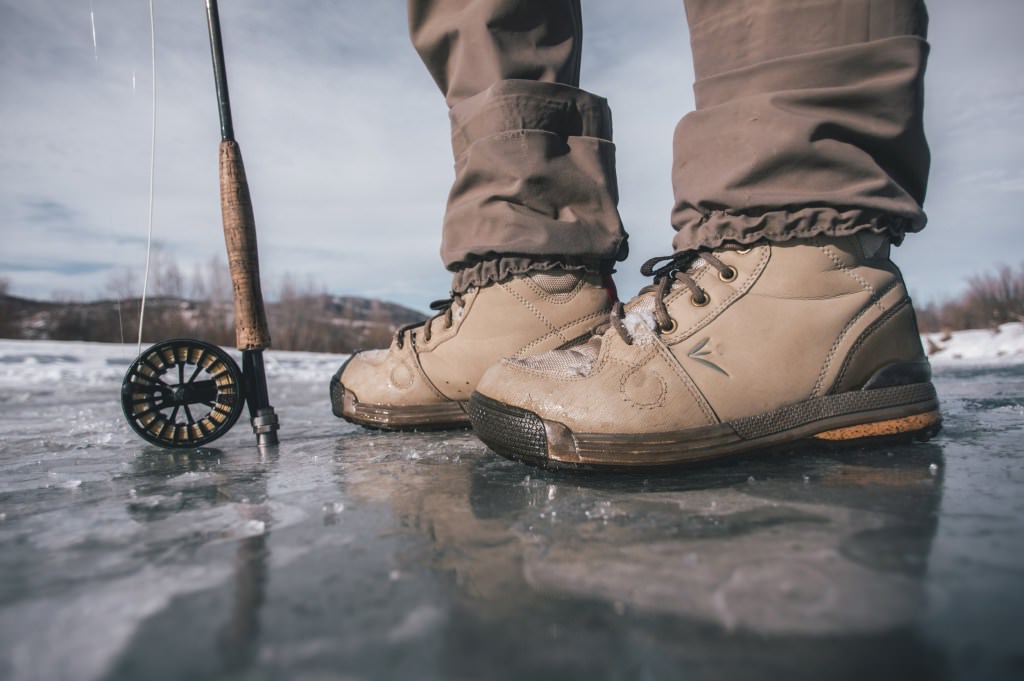 Standing on ice with a fly rod and winter boots.