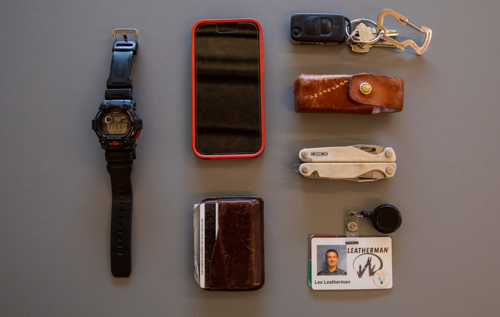 A Watch, phone, wallet, car keys with a carabiner, Leather sheath, modified Charge, and Lee Leatherman's ID badge