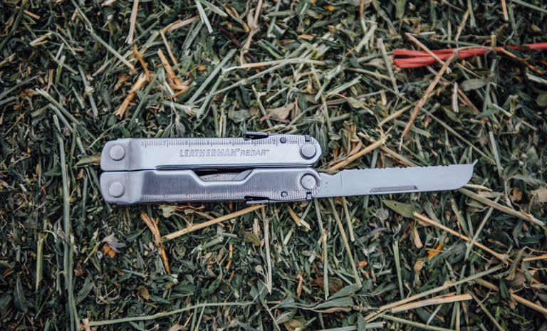 Leatherman stainless steel Rebar multi-tool on grass, knife blade open
